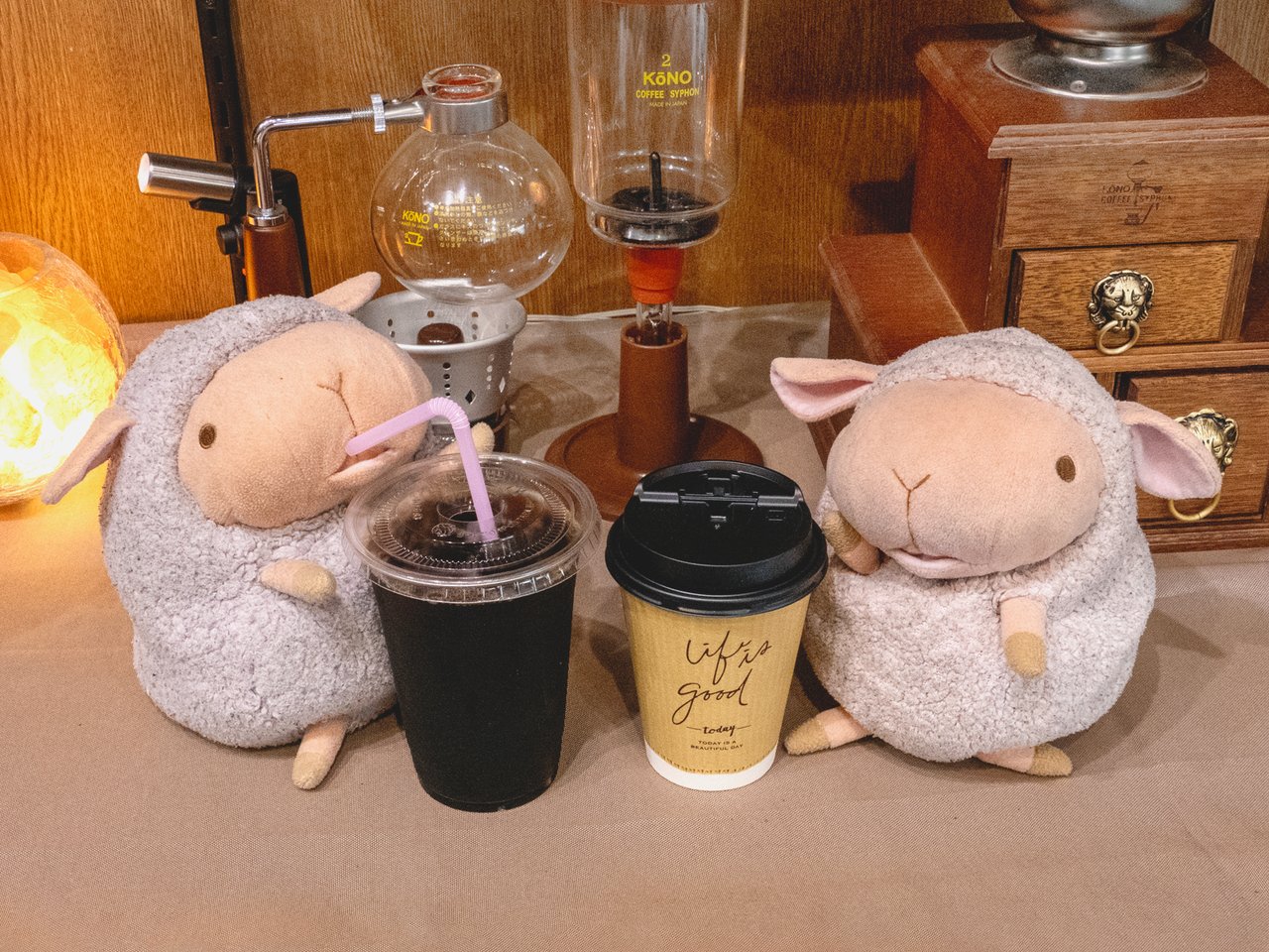 氷入りのアイスコーヒーの透明カップと、黒い蓋の紙コップのホットコーヒーが並んだテイクアウトの2つ